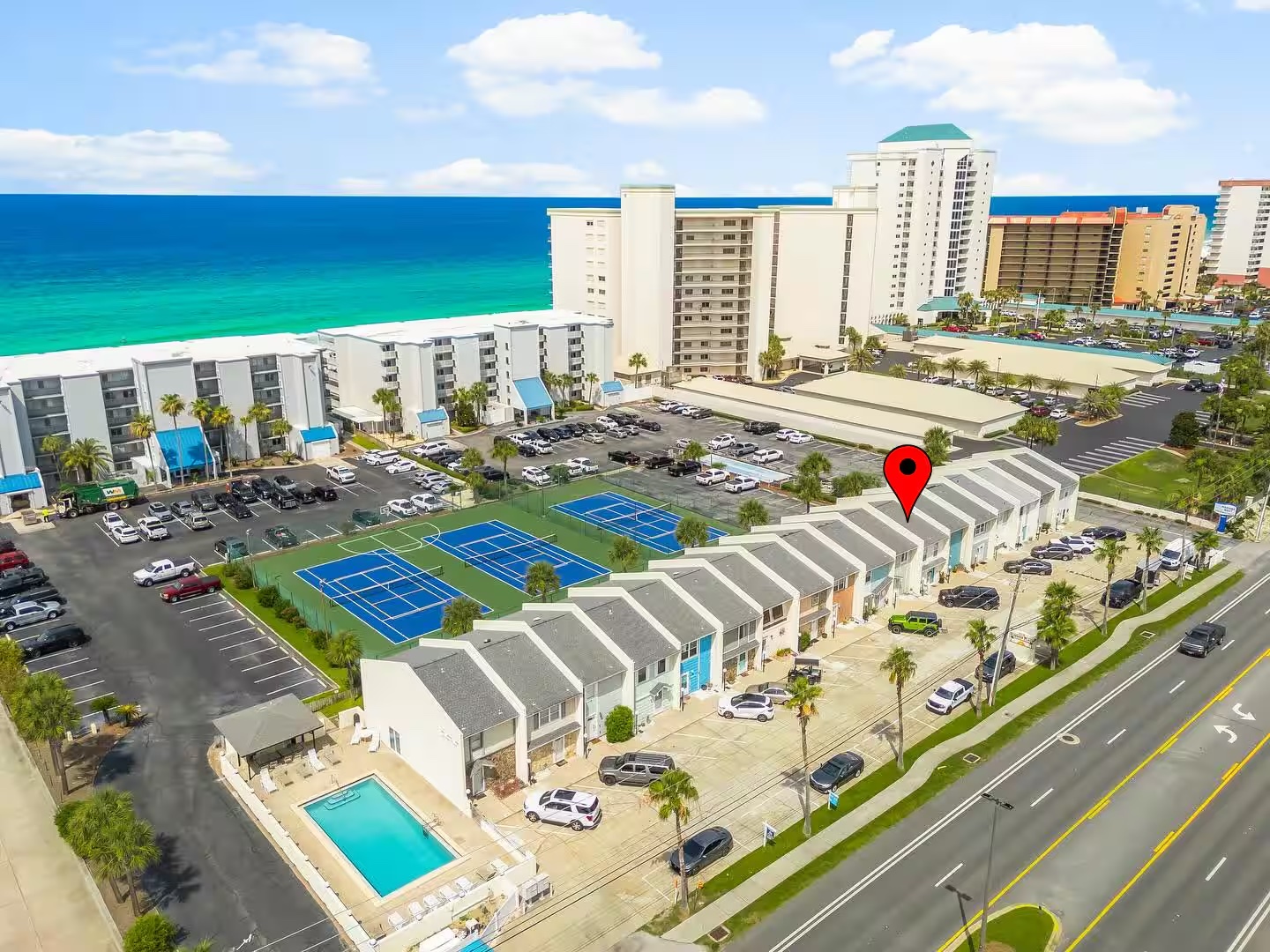 Aerial view showing exactly where the Turquoise Townhouse sits — pool, courts, and Gulf visible