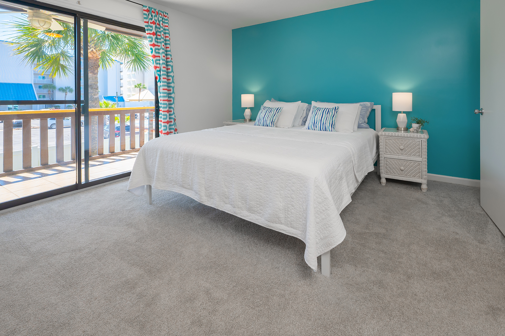 King bedroom with turquoise accent wall and private balcony