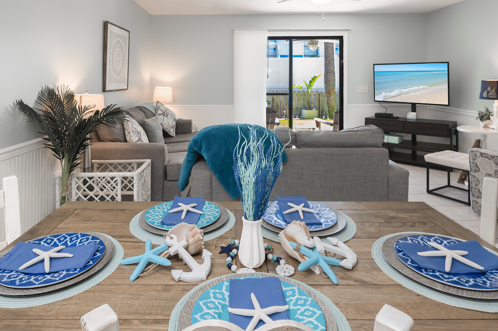 Beautifully set dining table and open coastal living room