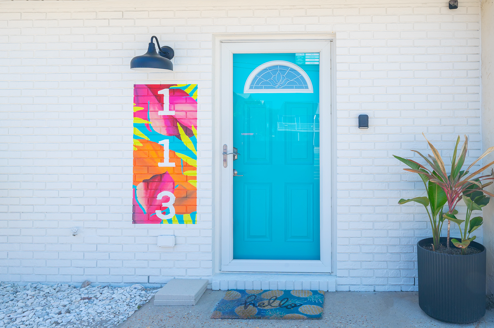 Iconic turquoise front door with hello welcome mat