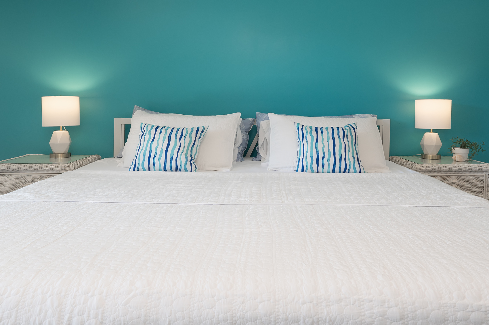 King bed with coastal accent wall — luxury hotel feel