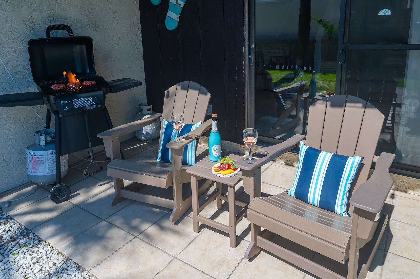 Private patio with gas grill and Adirondack chairs